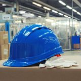A blue hard hat sitting on a factory workbench A blue hard hat sitting on a factory workbench