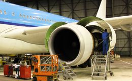 A mechanic working on a plane engine A mechanic working on a plane engine