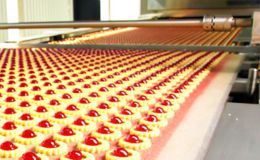 Mass production of a cherry dessert on a conveyor system Mass production of a cherry dessert on a conveyor system