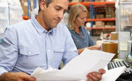 Man reading papers in a work setting Man reading papers in a work setting